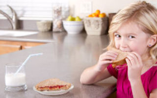 little girl eating pbj sandwich